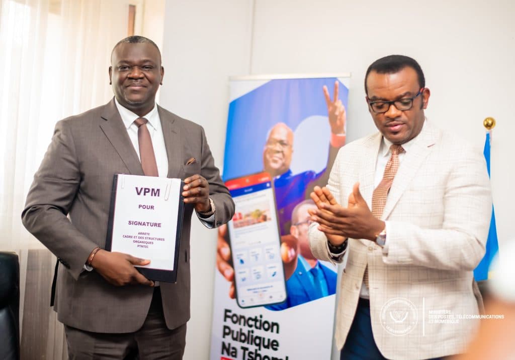 Augustin Kibassa Maliba recevant le nouveau cadre organique des PTNTIC des mains du VPM Jean-Pierre Lihau.